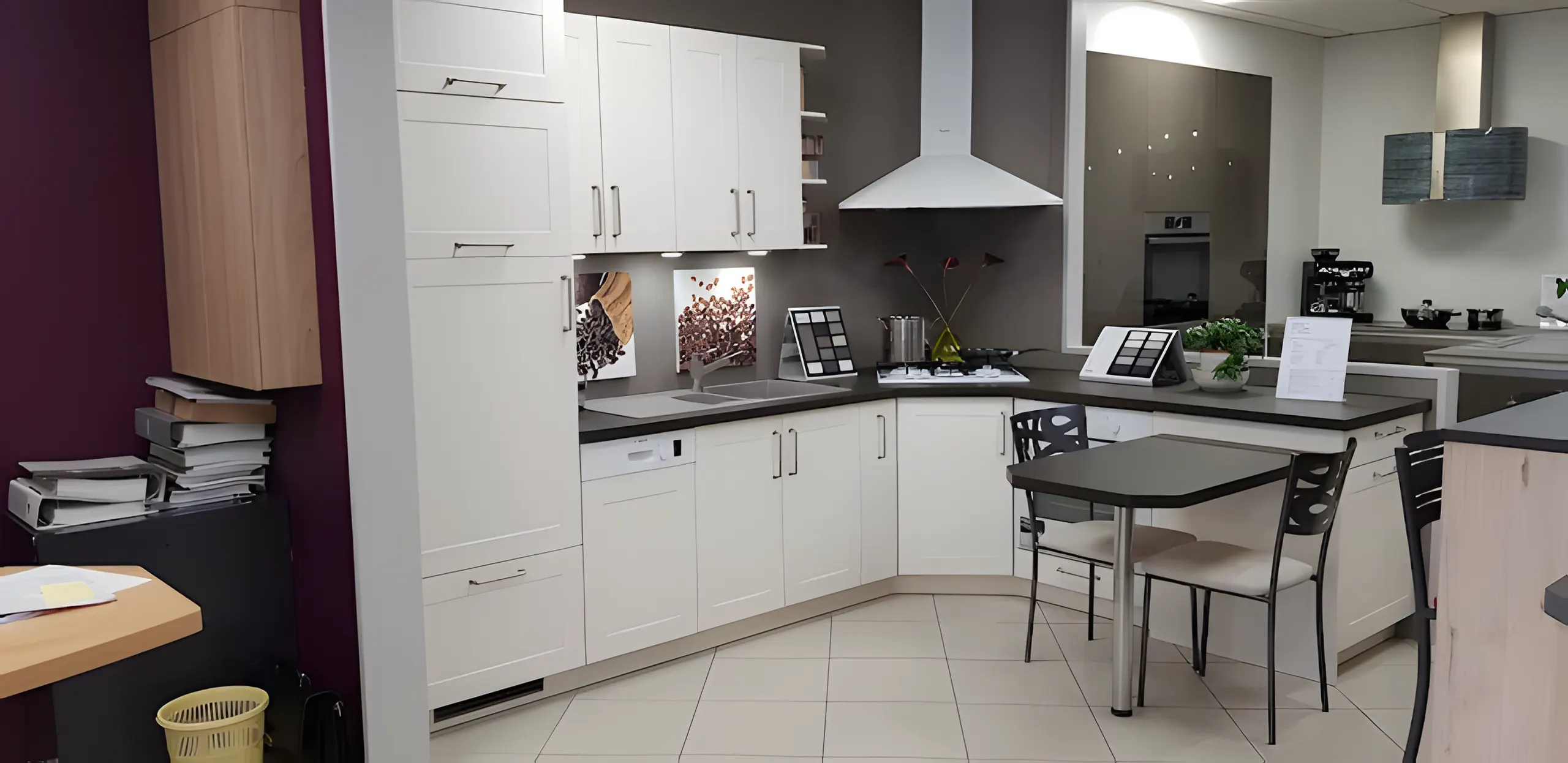 Cuisine blanche exposée au showroom, colonnes four et coin repas